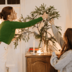 A two girls decorating a Christmas tree
