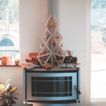 A mini christmas tree made of a wood and decorated with christmas balls