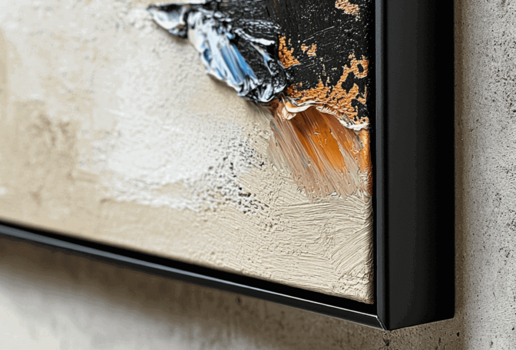 Close-up of a textured abstract painting in a black frame.