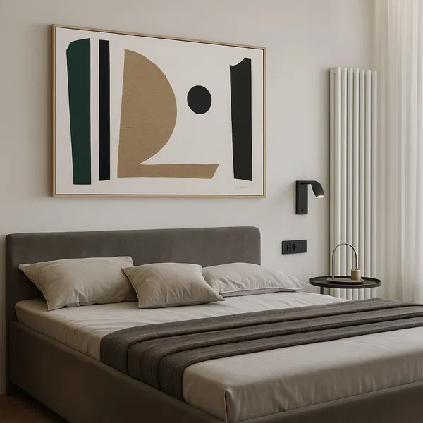 A bedroom with pillows and bedding, above the bed hangs a minimalist artwork in shades of green, black and gold.