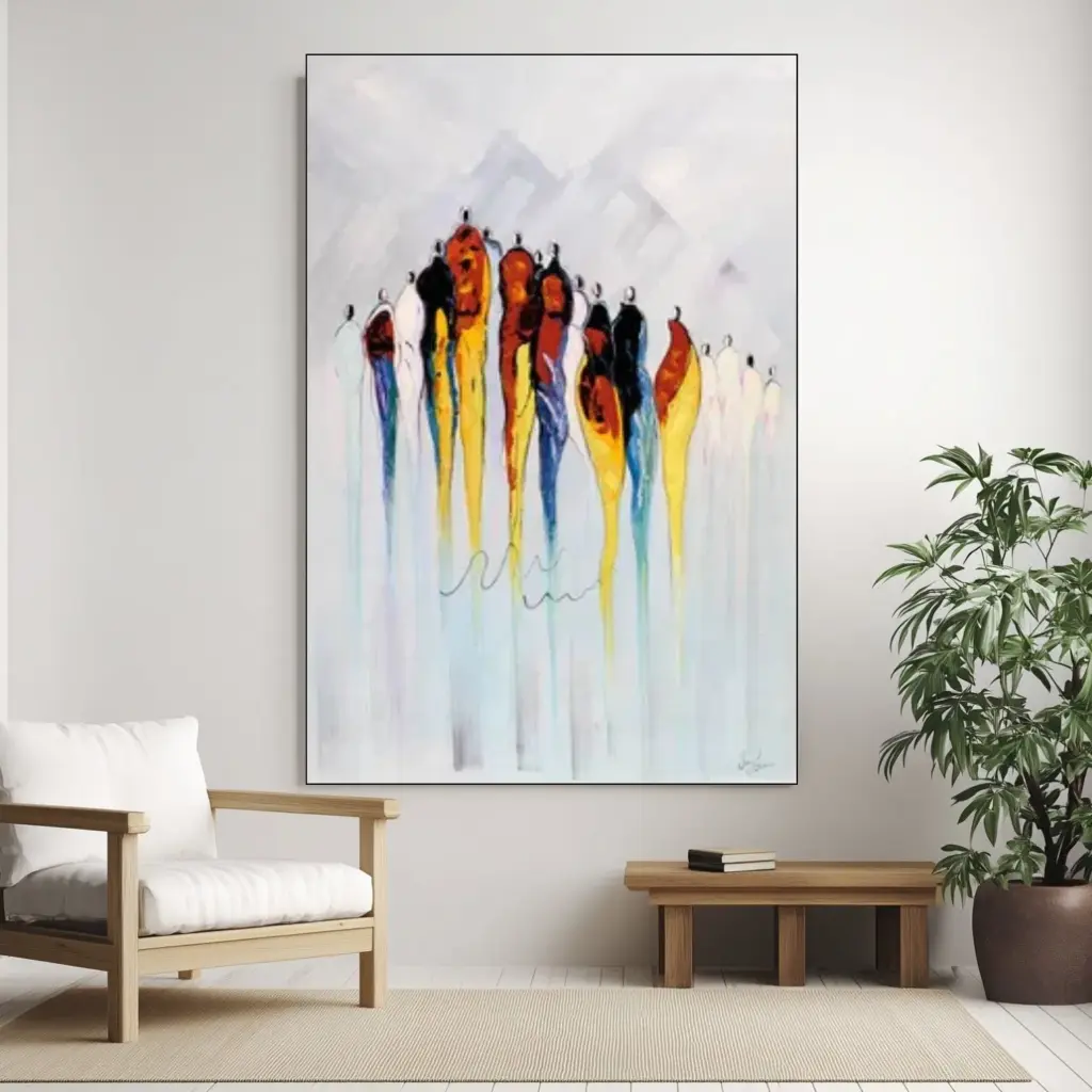 A vertical colorful abstract painting with dripping red, yellow, and blue paint strokes, displayed on a wall next to a white armchair.