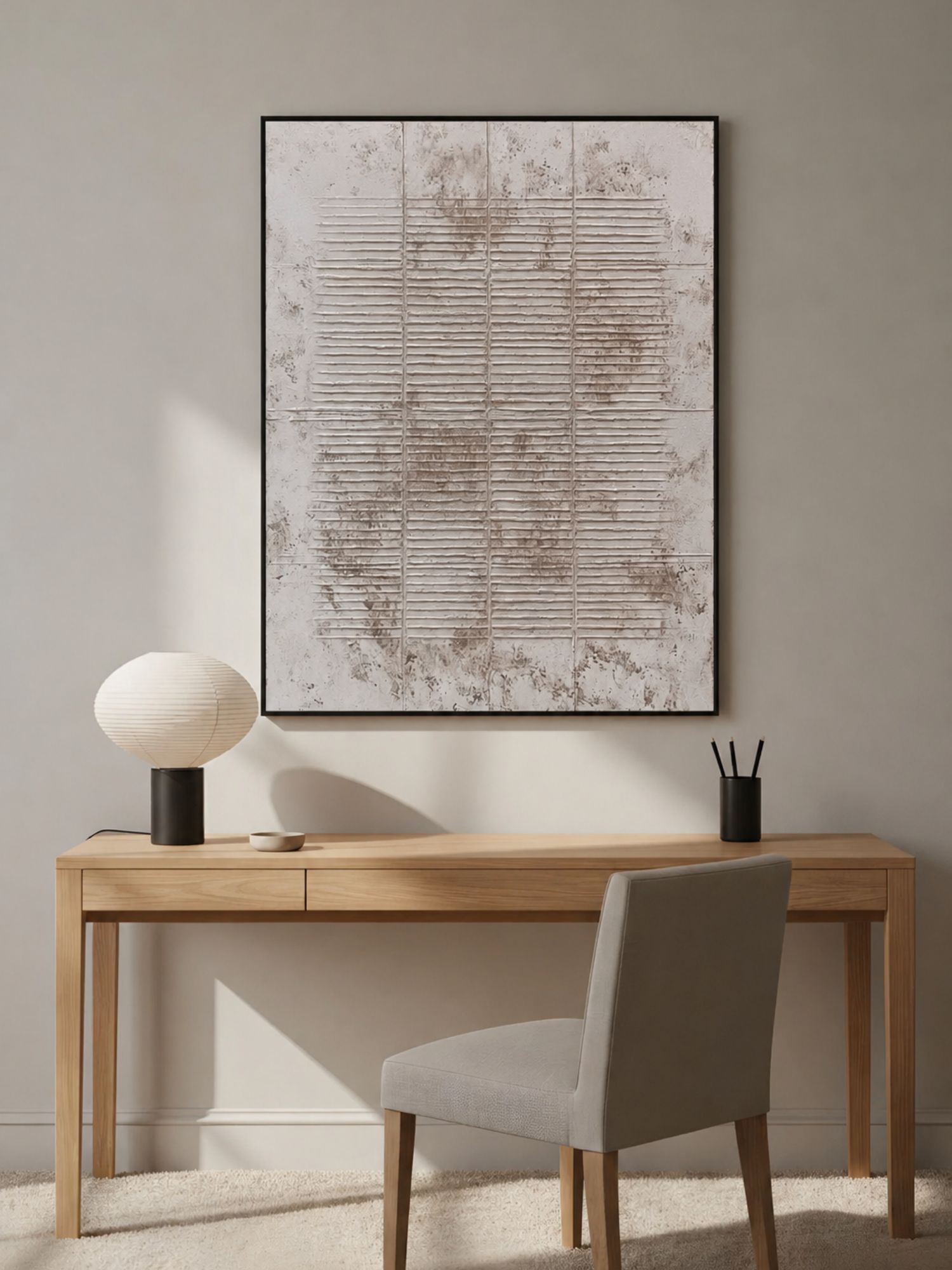 Minimal home office with vertical textured line artwork above a wooden desk.